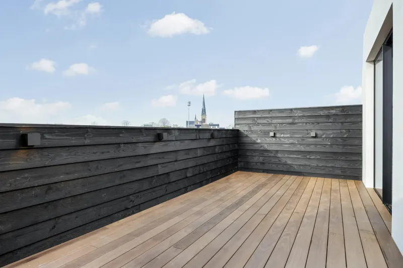 DuraTau decking on a rooftop terrace with black-stained cladding