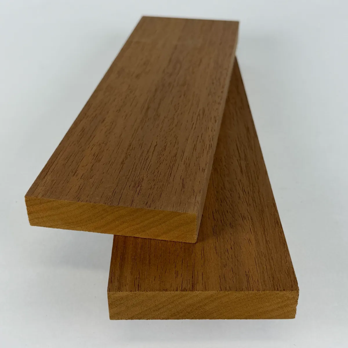 Two Nova Ambara® 1x4 S4S thermally modified hardwood boards stacked on a white studio background, surfaced face and square edges visible.