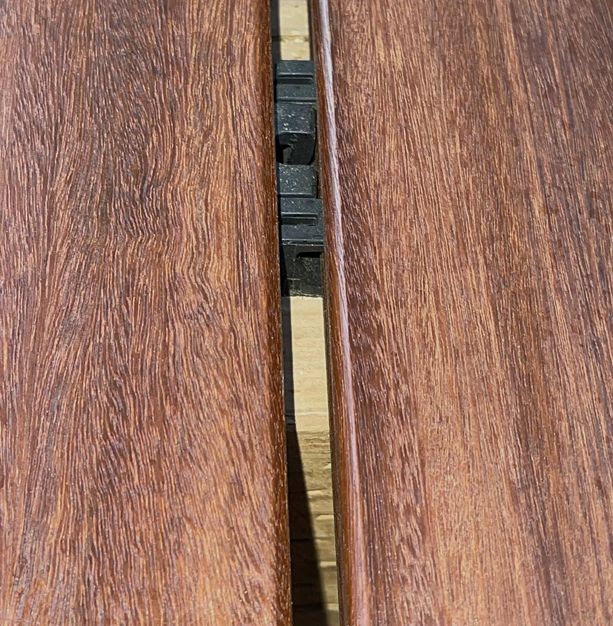 ExoDek QuickClip close up of installed clip in 5/4x4 Ipe grooved decking on 4x6 joists, 24 inches above ground.